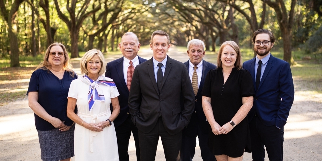 A Picture of the Clements McGovern Financial Consulting Group standing on a dirt road surrounded by overhanging trees